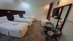 a hotel room with two beds and a mirror at فندق فيصل الصفوة in Al Khansāk +23 photos