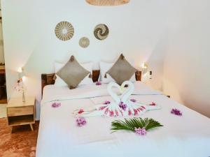 two swans towels on a bed in a room at Ocean Vibes Resort in Thong Sala