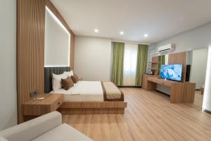 ein Schlafzimmer mit einem Bett und einem Fernseher in der Unterkunft Sever Suites Hotel in Antalya