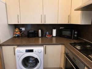 a kitchen with a washing machine and a microwave at 54 - Room 4 - Very spacious in Swansea