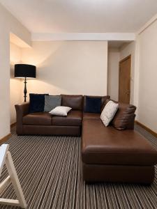 a living room with a brown couch and a chair at 54 - Room 4 - Very spacious in Swansea +3 photos