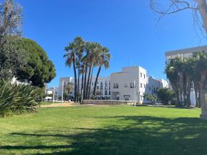a park in front of a building with palm trees at Pisos Isla Cristina 1 in Isla Cristina