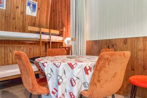 a dining room with a table and chairs and a bunk bed at L'Argentière - Nature - Calme - Ski in Le Bourg d'oisans