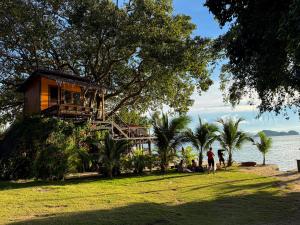 a tree house on a hill next to the water at Ocean Vibes Resort in Thong Sala
