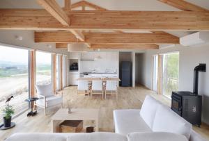 a living room with a white couch and a table at Adagio Retreat Tokachidake in Biei