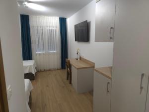 a white room with a desk and a bed at Hotel 81 in Međugorje