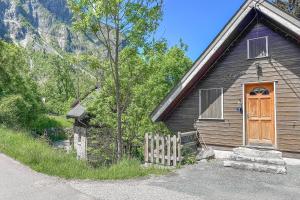 a brown house with a wooden door and a fence at L'Argentière - Nature - Calme - Ski in Le Bourg d'oisans