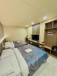 a hotel room with two beds and a flat screen tv at Skyport Hotel in Manila +46 photos