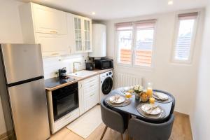 a kitchen with a table and a refrigerator at La Suite Prestige in Château-Thierry