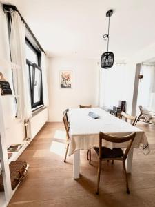 a white room with a table and chairs in it at De Blinker in Damme