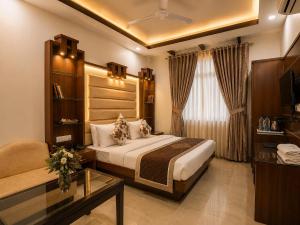 a bedroom with a bed and a living room at Hotel Baba Deluxe near New Delhi Railway Station and City Center -By RCG Hotels in New Delhi