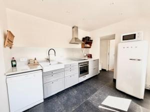 a kitchen with white appliances and a white refrigerator at De Blinker in Damme