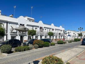 a street with cars parked in front of a building at Pisos Isla Cristina 2 in Isla Cristina