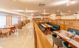 a restaurant with wooden tables and chairs and tablesktop at Hotel Grand Courtyard Pala in Pala