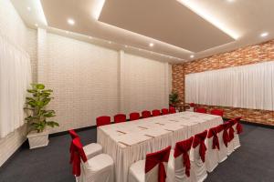 a conference room with a long table and red chairs at Hotel Grand Courtyard Pala in Pala