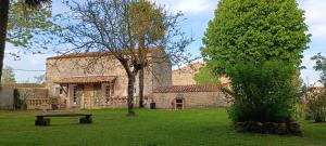 a stone house with a bench in the yard at Gîte Maelga in Cartelègue