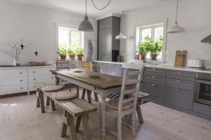 a kitchen with a wooden table and wooden chairs at Vallby Cottage in Enköping +20 photos