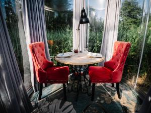 a table and two chairs in a room with a window at Nids des Marais in Ciney