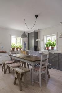 a kitchen with a wooden table and wooden chairs at Vallby Cottage in Enköping
