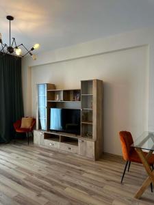 a living room with a entertainment center with a flat screen tv at Sol's M2 White Modern Apartments in Tbilisi City
