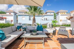 a patio with a couch and a table at Casa Cedro - Modern Golf Resort in Torre-Pacheco