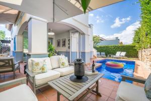 a patio with a pool and a table and chairs at Casa Cedro - Modern Golf Resort in Torre-Pacheco