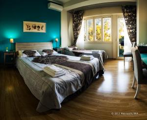 a bedroom with two beds and a large window at Metropolis B&B in Messina