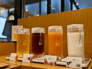 four glasses of beer sitting on a table at HOTEL SUI HAMAMATSU by ABEST in Hamamatsu