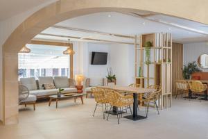 a living room with a table and chairs at SOL by Meliá Cala d'Or Apartamentos in Cala d´Or