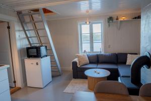 a living room with a couch and a microwave at Authentic rorbu by the sea in Stamsund