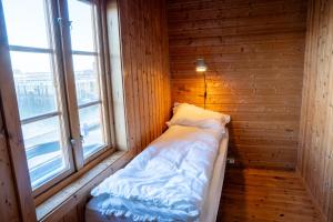 a small room with a bed and a window at Authentic rorbu by the sea in Stamsund