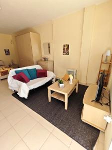 ein Zimmer mit einem Bett, einem Fernseher und einem Tisch in der Unterkunft Studio Open Horizons in Galaxidi