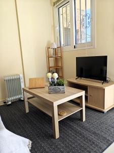 ein Wohnzimmer mit Fernseher und Couchtisch in der Unterkunft Studio Open Horizons in Galaxidi