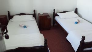 two beds in a room with white sheets at Guesthouse Mala Venecija in Virpazar