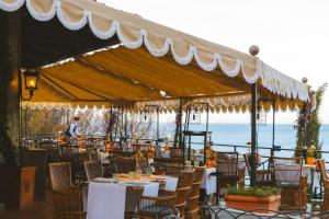 a restaurant with tables and chairs under a canopy at Il Pellicano in Porto Ercole
