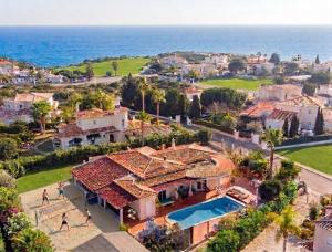 an aerial view of a house and the ocean at ALGARVE ONE - 8 rooms, 2 kitchens, private pool, billiard table and Beach-Volleyball Court in Carvoeiro