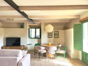 a living room with a table and chairs and a couch at La Casa de las Flores in Noceda del Bierzo