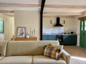 a living room with a couch and a kitchen at La Casa de las Flores in Noceda del Bierzo