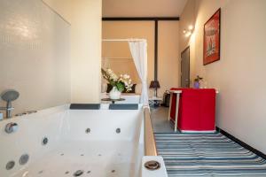 a bathroom with a white tub and a red refrigerator at Snob Luxury Suite in Cagliari