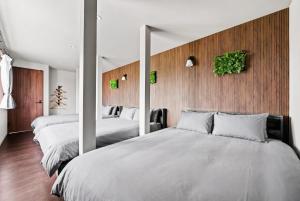 a bedroom with two beds and a wall with mirrors at VIOLET GARDEN - Vacation STAY 37201v in Furano