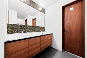 a bathroom with a sink and a wooden door at VIOLET GARDEN - Vacation STAY 37201v in Furano +54 photos