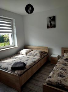 a bedroom with two beds and a window at Apartamenty NOVA - BLISKO ENERGYLANDII in Zator