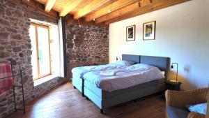 a bedroom with a bed in a brick wall at Domaine de Bellac - Le Triangle in Roussines +5 photos