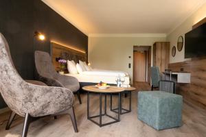 a hotel room with a bed and a table and chairs at Das Allgäu in Maierhöfen