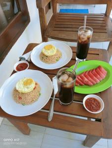 a table with two plates of food and a drink at Ani Bungalows in Gili Trawangan