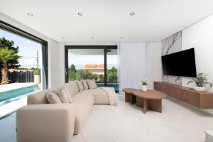 a living room with a white couch and a tv at Villa Perla Vir in Vir
