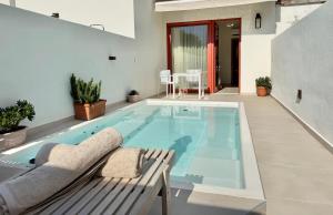 a large swimming pool with a bench in a house at Xanthos Beachfront Suites in Potamiá