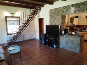 a living room with a staircase and a television at Casa Sasca Montana in Sasca Montană