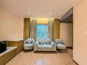 a living room with two chairs and a television at Jain Tree by Spree Hotels Vellore in Vellore