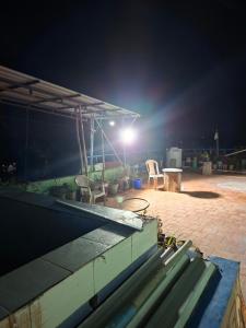 a patio with two chairs and a table at night at Terrace Camp inn in Tiruchirappalli